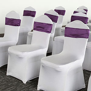 white banquet chair covers and purple decorative ribbons